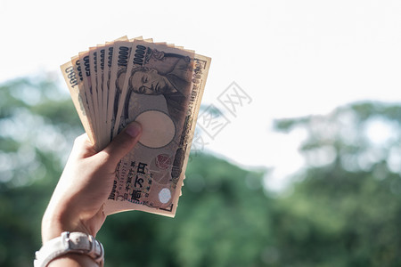 亚洲收入增值税持有日币钞票货投资金融和支付概念的女商人手持日元纸币堆叠商业金融和付款概念图片