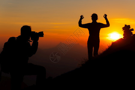 冒险景观山上摄影师是一个女孩日落瑜伽姿势在光影中服用图片
