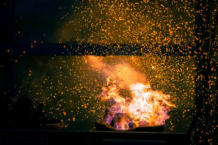 在黑暗抽象背景下燃烧木炭的火焰和花与bokeh烧焦模糊日志图片