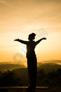 探索在山峰日出时自由欢呼的女士张开双臂天空金子图片