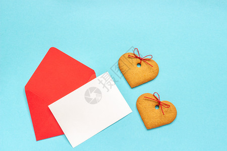 浪漫红信封空白纸卡用于文字和心形姜饼干放在蓝背景上翻版空间错装用爱的红信封打喜悦黑白纸卡放在蓝背景上复制邀请图片
