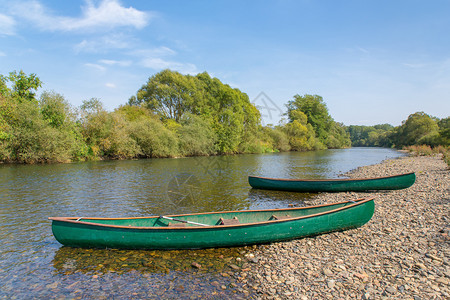 舍内维尔两艘绿色独木舟躺在河岸的里床季节图片