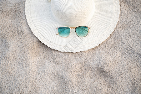 季节晴天优质的帽子和眼镜在晴朗的一天放海蓝滩上图片