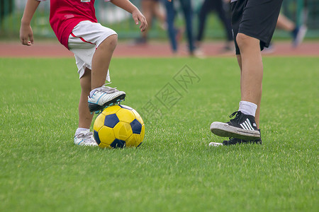 爱好孩子们的腿踢足球户外竞赛图片