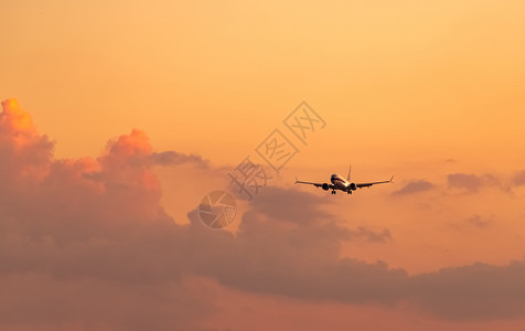 离开商业航空公司客机降落在场日天空和云雾飞抵行机在夜间航班开着照明的飞机陆线上行降落时间为晚航班空轮廓目的地图片