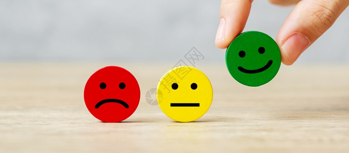 好的为了手持情感面块客户选择表情符号进行用户评论服务级排名客户评论满意度情绪评价和反馈概念堵塞背景图片