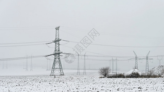 峰谷电价力量工程冬季风景中的高电压塔冬季雪价昂贵的供暖以及欧洲电价不断上涨等情况工业的背景