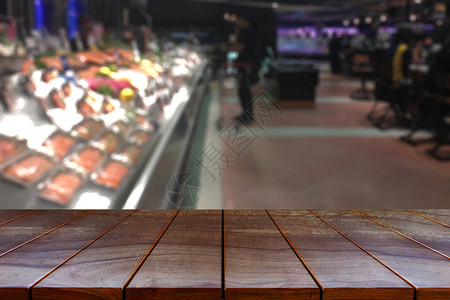 木头消费者店铺空木板桌间平台和模糊的超市过道产品展出时有架背景显示设备背景图片