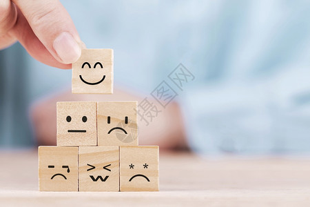 评分回馈商业人选择一个微笑的表情图标在木块服务与客户满意度调查概念上面对快乐的象征背景图片