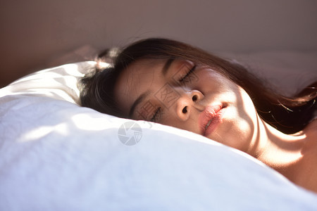 妇女睡在卧室的床上女人睡在士象征枕头图片