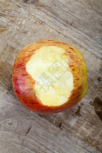 小吃明亮的躺在木头表面红苹果上有浅黄纸浆成熟的水果咬苹被图片