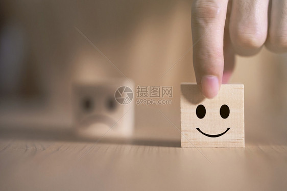 审查成功放松商人选择一个微笑的表情图标在木块服务与客户满意度调查概念上面对快乐的象征图片