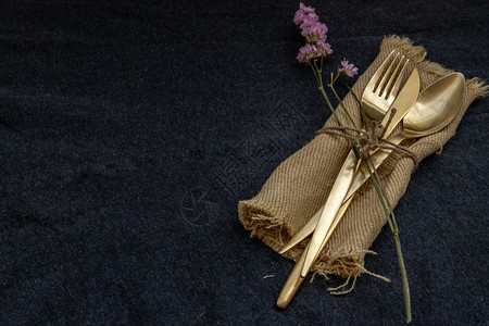 黄铜铬合金一组制餐具勺子叉和刀黑背景本底复制空间选择焦点青铜图片