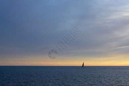 十一月1在西班牙马洛卡地中海上直平线与帆船沿中海上以粉色和蓝横穿红云景日落图片
