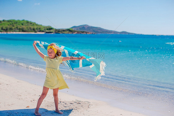 支撑闲暇旅行暑假在海滩上的可爱小女孩暑假在海滩上的可爱小女孩图片