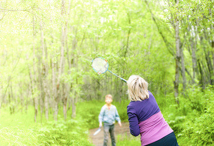 积极的活动微笑在树林里玩羽毛球的女子图片
