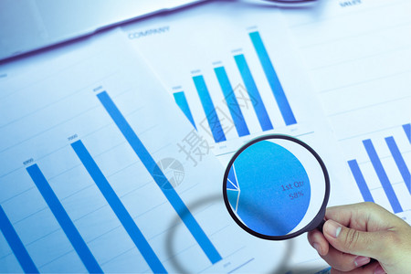 销售量利用放大镜从去年销售图中得出的商业分析和统计报告使用放大镜进行发公司的数据图片