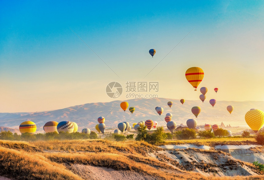 景观自然卡帕多西亚太阳和气球中的早日热空气球落图片