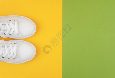 娱乐脚丫子速度白色运动鞋绿和黄背景鞋带的运动生活方式概念顶视图平躺复制空间白色运动鞋绿和黄背景鞋带运动图片