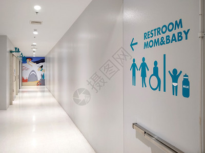 男蓝色的残疾人轮椅侧视和在购物中心区内清洁走廊的白色现代墙壁上的家庭卫生间标志其位置为标签图片