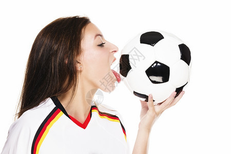 快乐的身穿足球衬衫美女舔着一个足球美女身着衬衫在白色背景的足球上舔着一只橄榄球喜悦女士图片