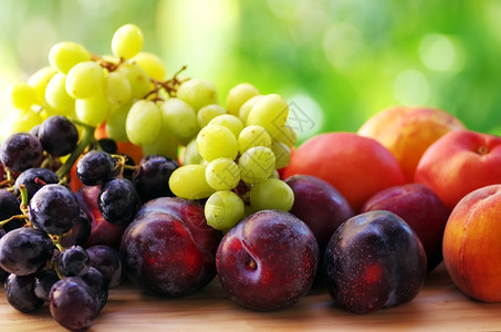 生的新鲜成熟水果近的李子桃和葡萄束湿的图片