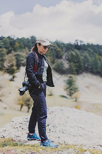 漫步在山间的女摄影师冒险徒步旅行顶峰悬崖高清图片素材