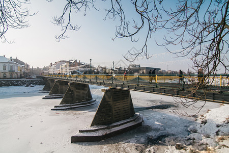建筑学河老的Uzhgorod城市中心带冰雪的乌日哥罗德人行桥图片