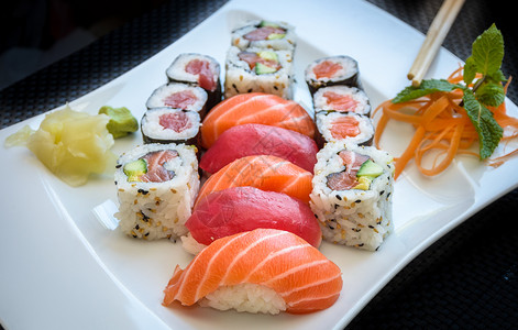寿司马基和加州滚轮配着姜子和黄瓜盘上摆着筷寿司马基和加州滚盘上摆着子美味的熟食健康图片