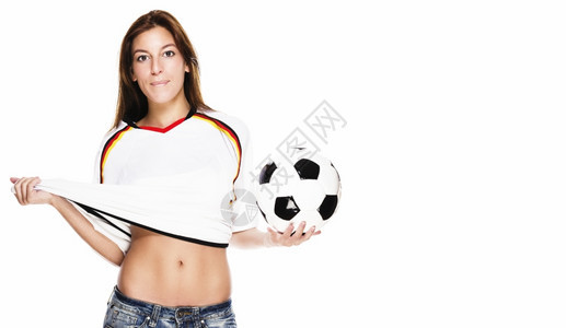 时间年轻漂亮的女人拿着足球拉她的衬衫年轻漂亮的女人拿着足球拉她的衬衫在白色背景保持快乐的图片