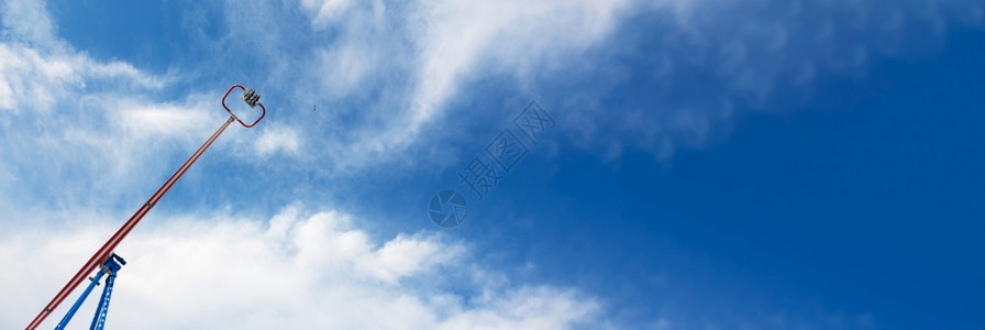 娱乐人们骑着蓝色天空背景的极端旋转木马全景模拟图像丰富多彩的快乐图片