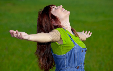 天绿色美丽的快乐女人在绿草地上张开双臂春天图片