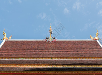 老的云传统在明蓝天空下教堂屋顶上的金鸟雕塑带有泰国传统北风格的复制空间泰国北部风格图片