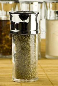在一个玻璃罐子里的干马约拉姆叶子放在木垫上不同的香料背景上丰富多彩的粉末洋葱图片