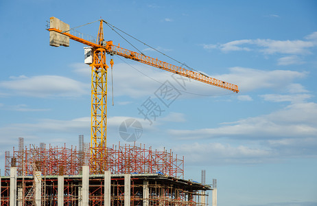 住宅黄塔起重机和正在建筑中的以蓝天空工业概念为参照建造地背景筑地点图片