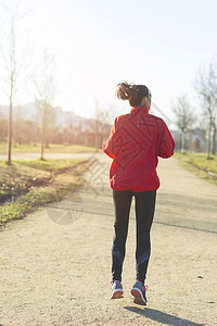 训练森林女跑车手在公园慢锻炼图片