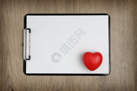 考试黑色剪贴板有空白皮书和木背景的心脏形状信头复制图片