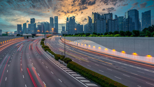 中央新加坡人运动城市高速公路交通车灯与新加坡市景天际和摩大楼背景的汽车光线移动图片