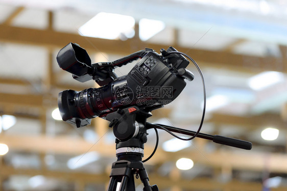 摄影棚中General专业录像摄机在模糊灯光背景的三脚架上拍摄5月描绘了第三方IP工作室生产摄像师图片