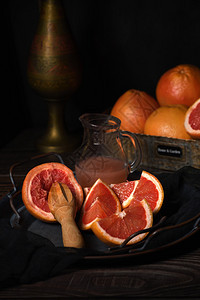 生态低卡路里新鲜葡萄汁的切片为在黑暗背景的盘子上制造新鲜果汁而准备的图片