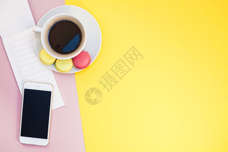 风格办公室粉色的有创意平版咖啡杯相片配有马卡龙和一张纸条带有粉红和黄色背景最低风格的复制空间手机的背景