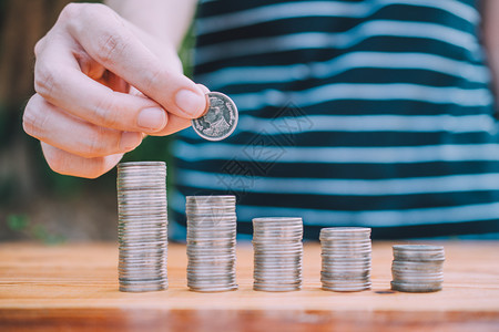 价格手持硬币和木桌纸堆叠的硬商业融资概念营销订金图片
