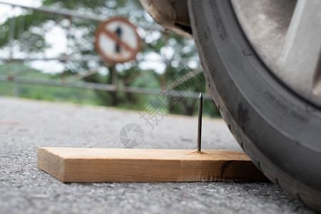 把木板上的铁钉紧贴在木头上几乎穿入轮胎安全粉碎模糊图片
