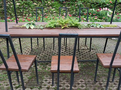 户外座位花园砖地上的金属架板桌和加里茶杯自然图片