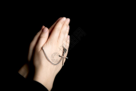 祷告祈手拿着念珠特写手拿着项链在黑暗中为上帝祈祷带有复制空间背景的宗教基督符号祈祷手拿着念珠宗教基督符号书宗的图片