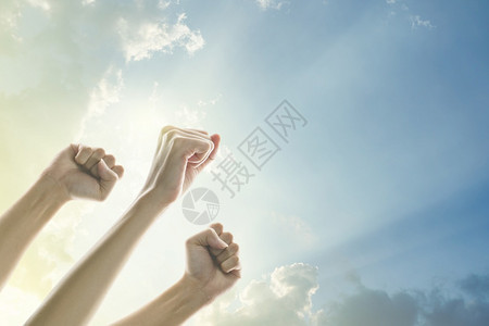 领导在空气中长大的人拳头有着明亮的天空和阳光背景愤怒团队合作背景图片
