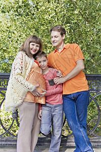 快乐的橙子家庭与怀孕的母亲在河边幸福的橙子家庭期待四十孩子图片