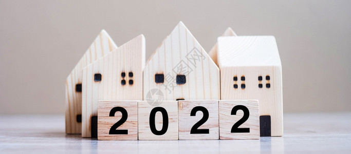 银行房地产投资金融储蓄和解决新年问题概念快乐在桌木本底背景上采用住房模式收入建造住宅图片