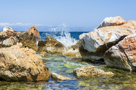 沿海浪在石滩上破碎形成浪花希腊海在石滩上破碎形成浪花一种晴天图片