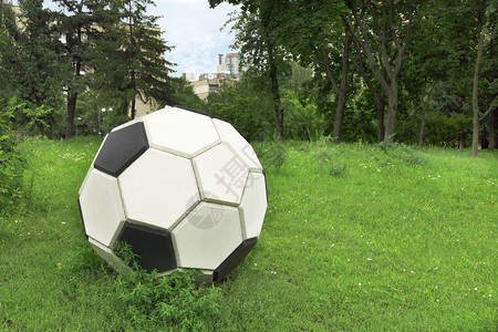 现代的闲暇程式化城市公园间清空的绿草坪上金属平板化足球在绿色草坪上的金属平板化足球图片